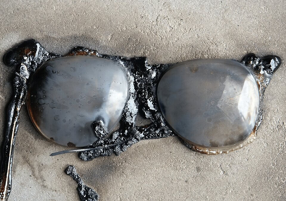 Eyeglasses made of metal melting into sidewalk