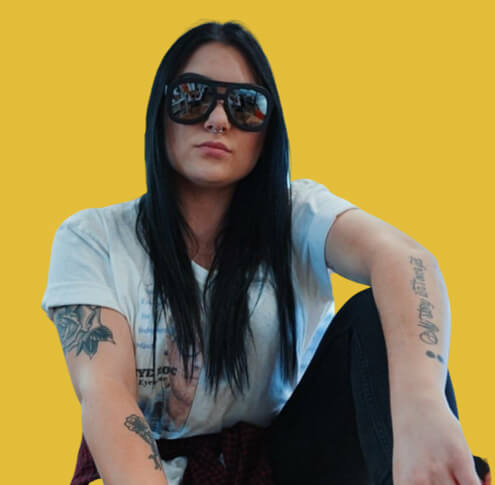 A woman wearing cool sunglasses against yellow background