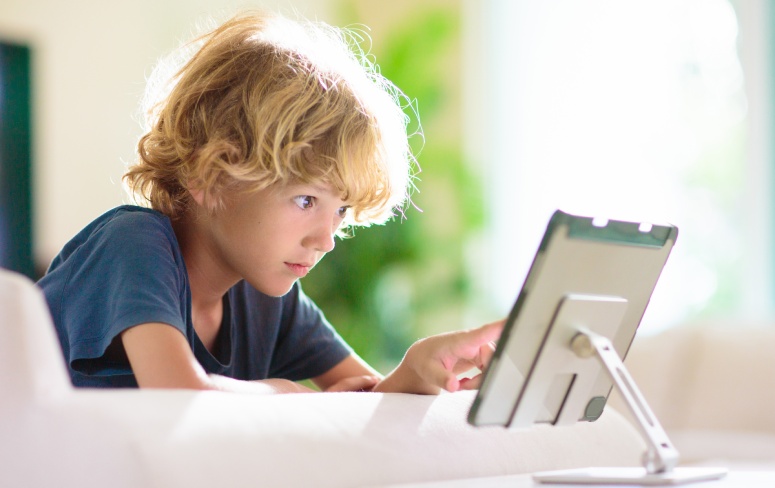 Blond haired kid using a tablet